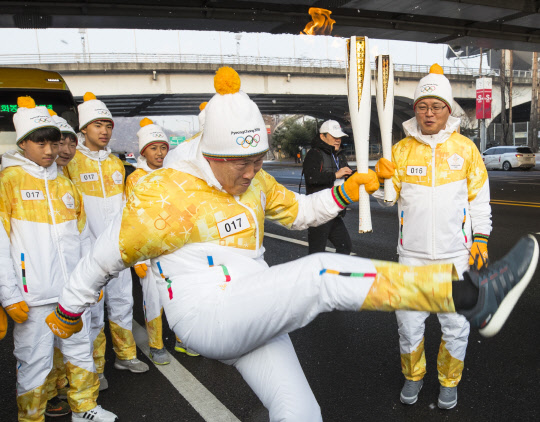 13일 오전 서울 마포구 월드컵경기장 앞에서 차범근 전 축구대표팀 감독이 축구 꿈나무들과 함께 성화를 전달 받은 후 볼을 차는 퍼포먼스를 하고 있다.